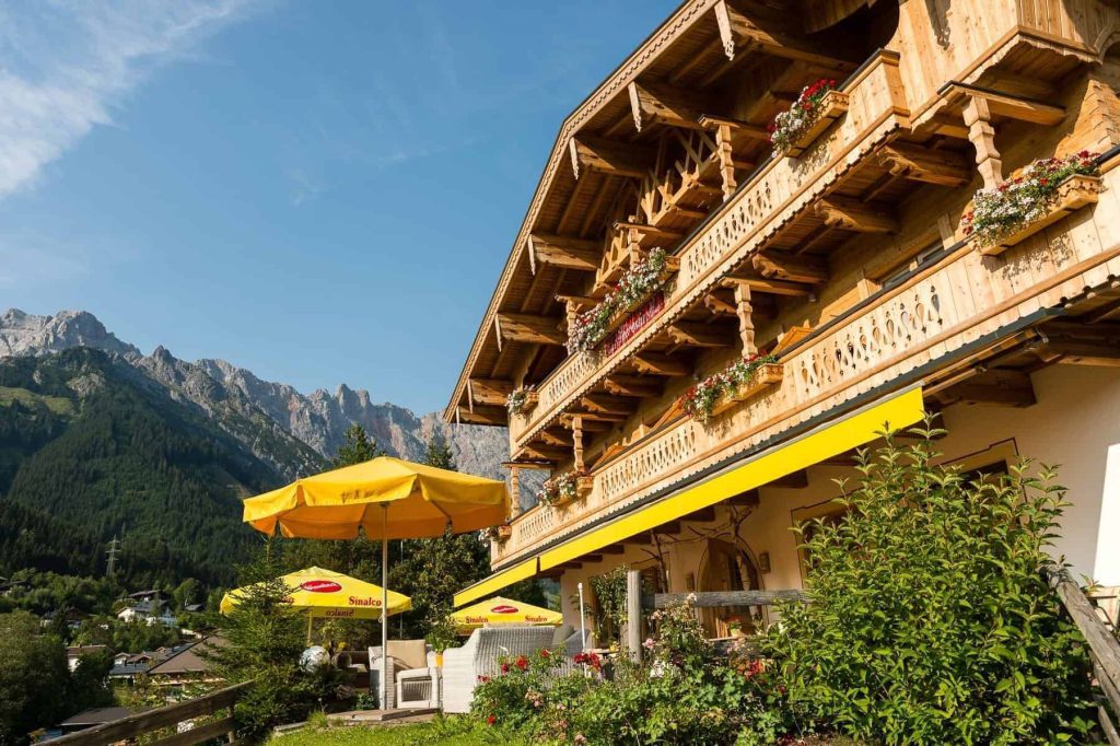 Cozy Hotel Guesthouse with a Balcony and Yellow Umbrellas, Surrounded by Picturesque Mountains.